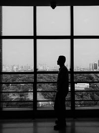 Man standing by window at home