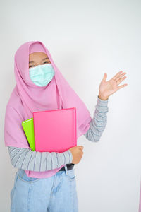 Midsection of woman holding umbrella against white background