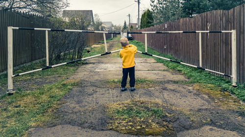 Full length rear view of man walking on footpath