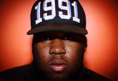 Close-up portrait of young man wearing cap against red background