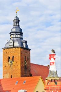 Low angle view of bell tower against cloudy sky