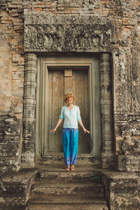 Smiling mid adult woman standing outside ankor wat temple