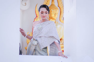 Young woman wearing traditional clothes standing at temple