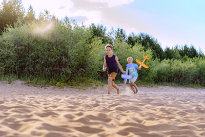 Side view of woman playing with sand at beach