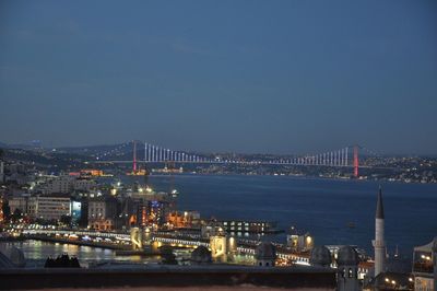 Illuminated bridge over river at night