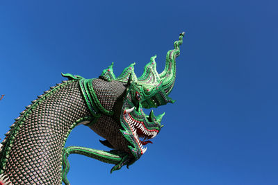 Low angle view of statue against blue sky