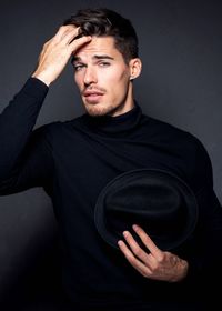 Portrait of man wearing mask against black background