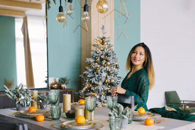Pretty woman in a turquoise dress serves a festive table for the holiday