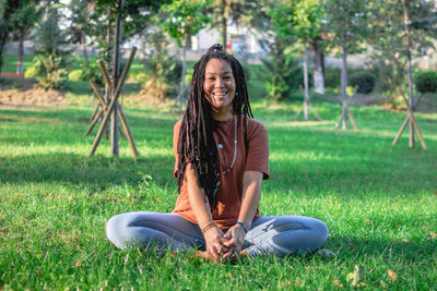 Smiling woman is doing yoga exercise outside in a park. concept of healthy lifestyle.