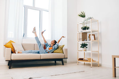 Young woman sitting on sofa at home