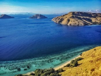 Scenic view of sea and mountains against blue sky