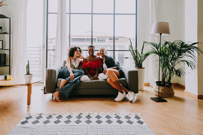 Couple using digital tablet while sitting on sofa at home