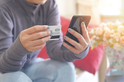 Midsection of woman using mobile phone