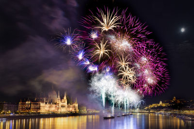 View of firework display over river at night