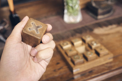 Cropped hand of woman holding wooden block