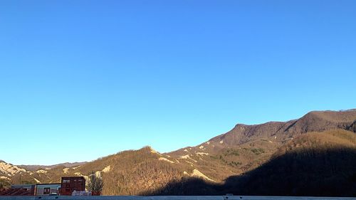 Scenic view of mountains against clear blue sky