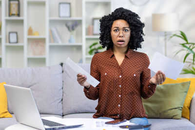 Portrait of woman using laptop while sitting on table