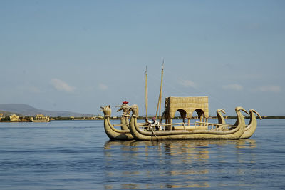 Fishing boat in lake against sky