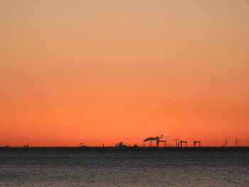 Scenic view of sea against orange sky