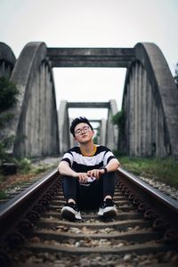 Portrait of man sitting on railroad track