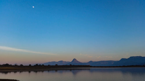 Scenic view of lake against clear blue sky