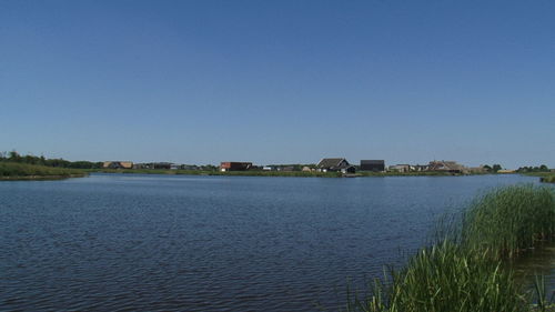 Calm sea against clear blue sky