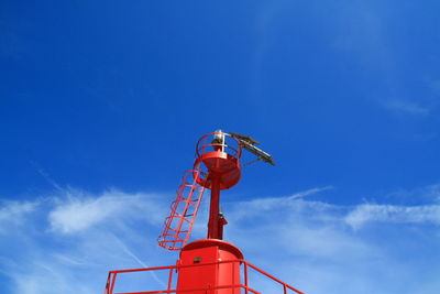 Low angle view of red umbrella against blue sky