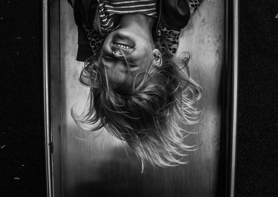 Upside down image of playful girl on slide at park