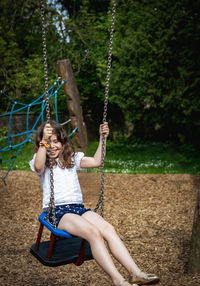 Boy swinging at playground