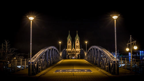 Illuminated bridge against sky at night