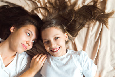 Sisters having fun on beige color textile background