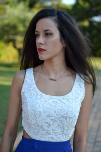 Portrait of beautiful young woman standing against blurred background