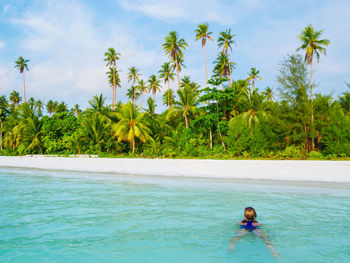 Man in swimming pool by sea against sky