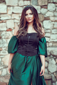 Portrait of beautiful woman standing against wall