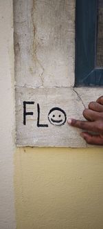 Cropped hand of person drawing on wall