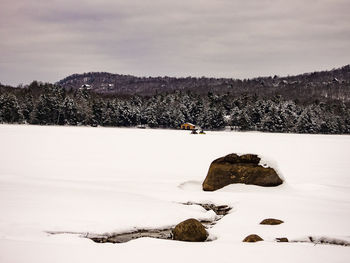 Scenic view of snow covered field against sky