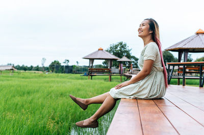 Side view of woman sitting outdoors