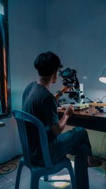 Man using mobile phone while sitting on chair at home