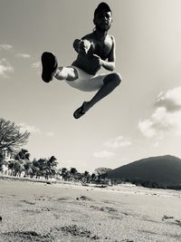 Full length of man jumping against sky