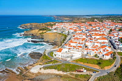 High angle view of buildings by sea against sky