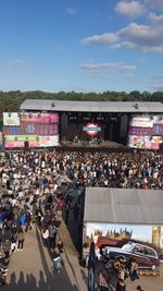 Crowd in city against sky