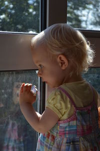 Cute little girl gazing out of flat window