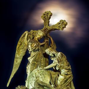 Low angle view of angel statue against sky at night