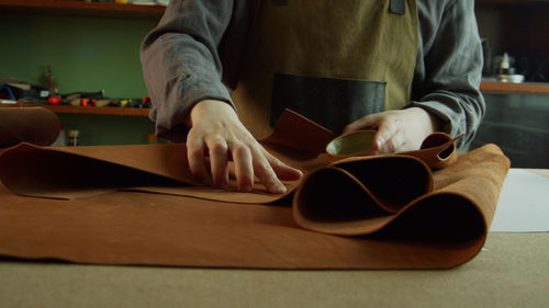 Midsection of man reading book on table