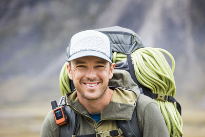 Portrait of climber wearing backpack, rope and gps communication tool
