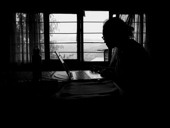 Side view of man using laptop on table