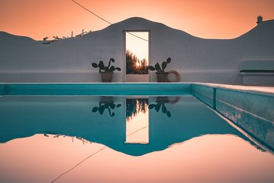 Reflection of swimming pool in sea against clear sky