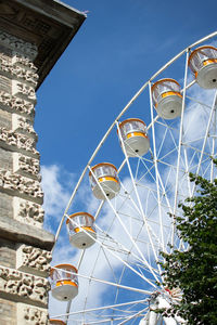 Low angle view of ferris wheel against blue sky