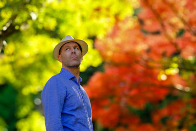 Portrait of young woman standing against plants