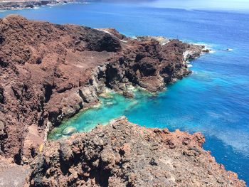 High angle view of rocks on sea shore against sky
